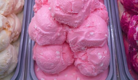 Balls of pink strawberry ice cream.