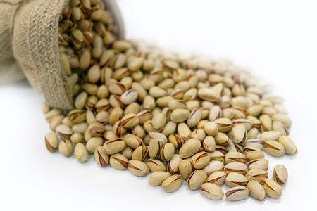 Pistachios in a canvas bag on a white background.の写真素材
