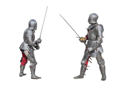 Knights in armor. Medieval knights in iron armor hold swords in their hands. Duel of the medieval warriors. The battle of two knights on swords.の写真素材