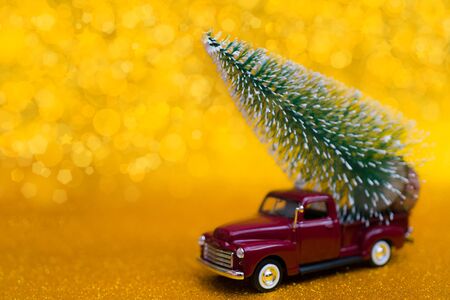 Toy car carries Christmas tree for holiday.の写真素材