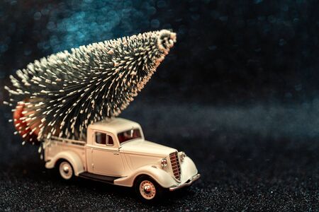Toy car carries Christmas tree for holiday.の写真素材
