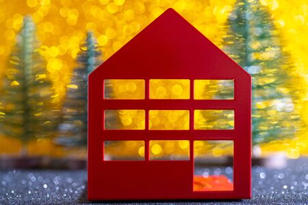 Green christmas tree on shiny background. Beautiful bokeh. Little red house.の写真素材