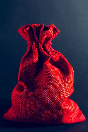Red bag of Christmas gifts on a black background.の写真素材