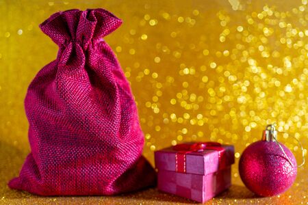 Christmas golden background. Red gift bag and Christmas toys.の写真素材