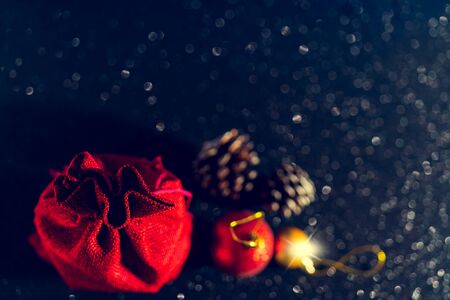 Christmas shiny black background. Red gift bag and Christmas toys.の写真素材