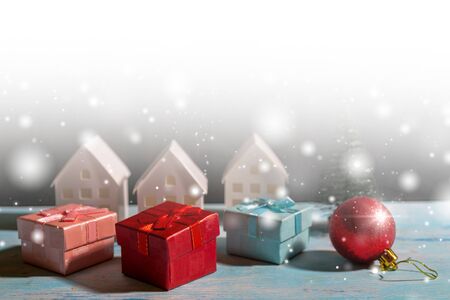 Christmas snowfall in small village. Christmas gift boxes.の写真素材