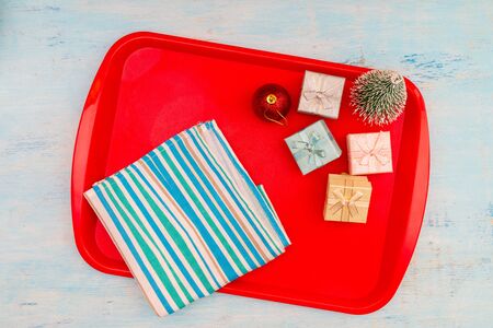 Christmas composition. Christmas gift boxes. Red plastic dining tray on the table.の写真素材