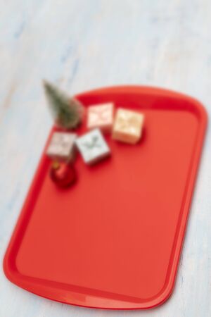 Christmas composition. Christmas gift boxes. Red plastic dining tray on the table.の写真素材