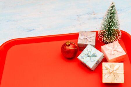 Christmas composition. Christmas gift boxes. Red plastic dining tray on the table.の写真素材
