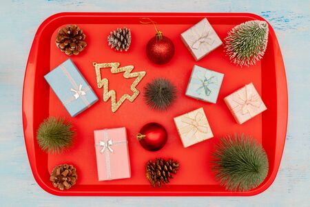 Christmas composition. Christmas gift boxes. Red plastic dining tray on the table.の写真素材