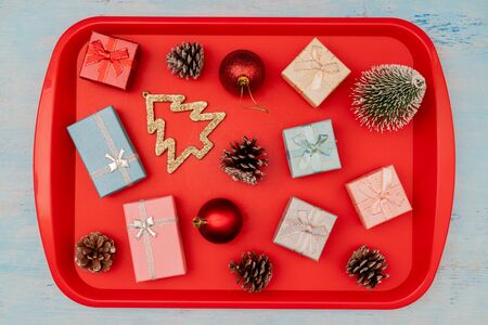 Christmas composition. Christmas gift boxes. Red plastic dining tray on the table.の写真素材