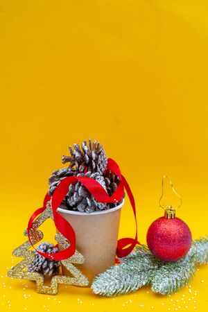 Christmas composition. Fir cones in paper cup for coffee. Holiday decoration elements.の写真素材