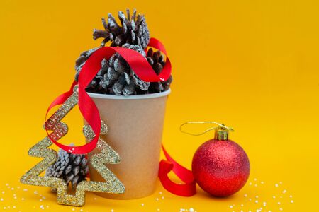 Christmas composition. Fir cones in paper cup for coffee. Holiday decoration elements.の写真素材