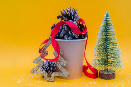 Christmas composition. Fir cones in paper cup for coffee. Holiday decoration elements.の写真素材