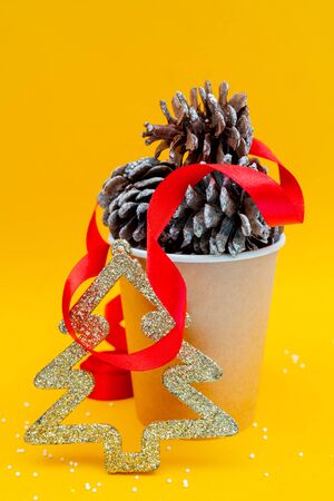Christmas composition. Fir cones in paper cup for coffee. Holiday decoration elements.の写真素材