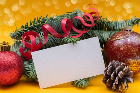 Christmas composition on yellow background. Branches of spruce, cones and balls. Copy space.の写真素材