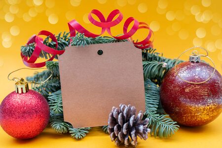 Christmas composition on yellow background. Branches of spruce, cones and balls. Copy space.の写真素材