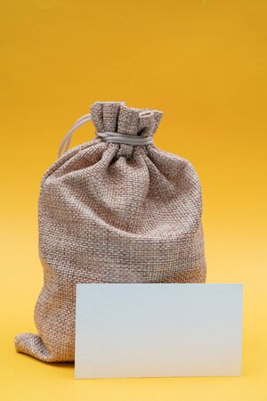 Christmas composition on a yellow background. Canvas gift bag of Santa Claus.の写真素材