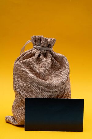 Christmas composition on a yellow background. Canvas gift bag of Santa Claus.の写真素材
