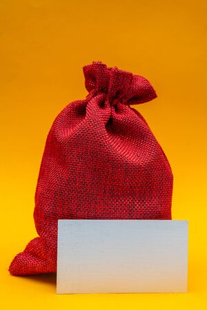Christmas composition on a yellow background. Red canvas gift bag of Santa Claus.の写真素材