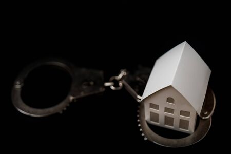 Little white paper house on a black background.の写真素材