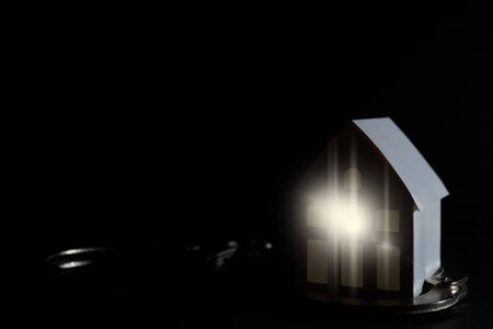 Little white paper house on a black background.の写真素材