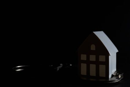 Little white paper house on a black background.の写真素材
