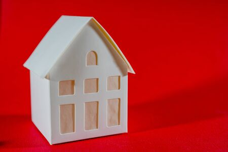 Little white paper house on a red background. Property For Sale.の写真素材