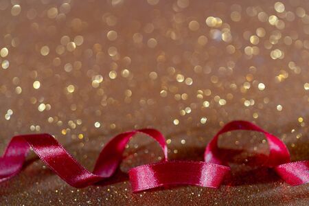 Red wavy ribbon on gold background. Holiday decoration. Decorative congratulation frameの写真素材
