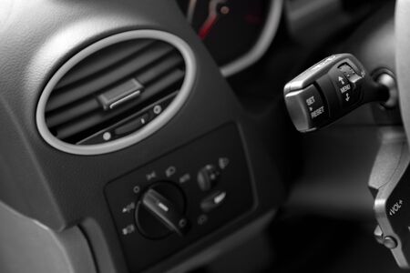Soft focus interior of car. Car seats for driver and passenger. Steering wheel.