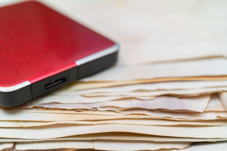 Hard drive for storing information. Stack of vintage paper. Old yellow sheets of paper. Yellow pages of the book.の写真素材