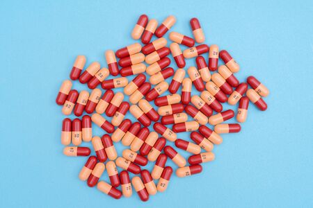 Medicine pills or capsules on blue background with copy space. Medicinal prescription for drug...