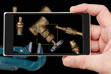 Plumbing tools on black background. Faucets, valve, pipe wrench to repair water supply system. の写真素材