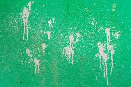 Spray of white paint on green wall. Abstract green background.の写真素材