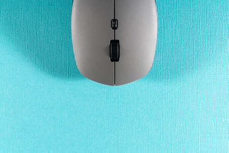 Wireless computer mouse on a blue background. Modern computer technologies.の写真素材