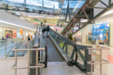 Blurred escalator in a supermarket. Selling goods in a retail store. Blurred background of customers...