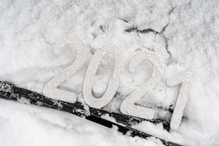 The inscription 2021 on the snow. Holiday of light Christmas and New Year.の写真素材