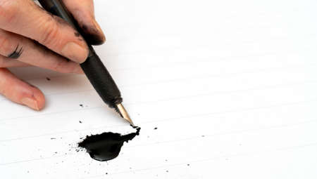Calligraphy training. Fountain pen in ink-stained hands.の写真素材