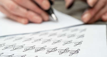 Calligraphy training. Fountain pen in ink-stained hands.の写真素材