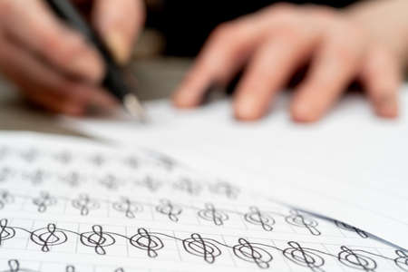 Calligraphy training. Fountain pen in ink-stained hands.の写真素材
