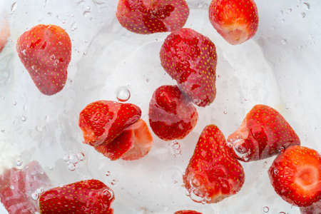 Ripe red strawberries are washed in water. A useful berry for farming.の写真素材