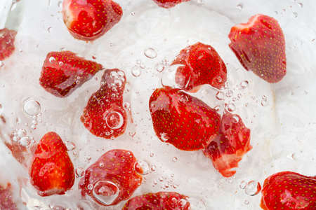 Ripe red strawberries are washed in water. A useful berry for farming.の写真素材