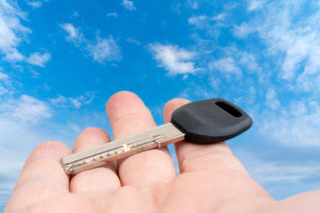 Metal door key in a man's hand. Sale and rental of real estate.の写真素材