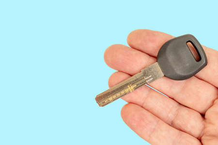 Metal door key in a man's hand. Sale and rental of real estate.の写真素材