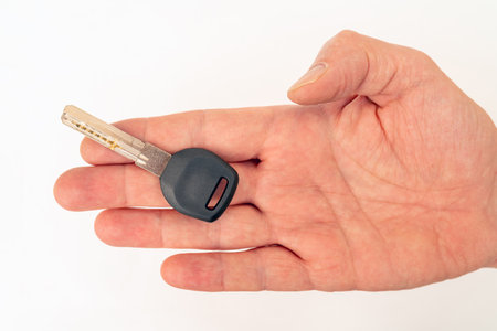 Metal door key in a man's hand. Sale and rental of real estate.の写真素材