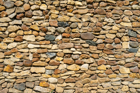 Wall of yellow stone. Abstract natural background. Uneven stone surface.の写真素材