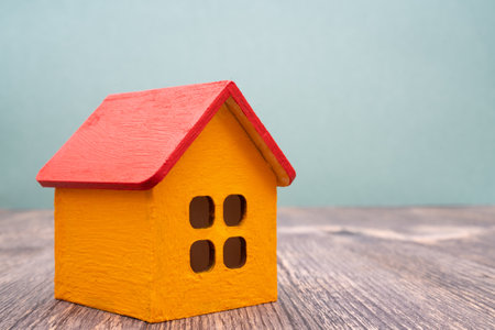 Model of a wooden yellow house with a red roof. Rent and sale of buildings and cottages.の写真素材