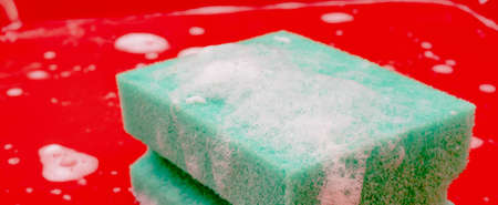Disinfection of red plastic food tray in fast food. Washing the tray with a sponge and soap.の写真素材