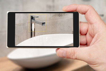 Water tap on smartphone screen. Water tap and sink in the bathroom. The interior of the living quarters.の写真素材