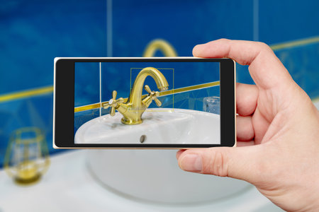 Water tap on smartphone screen. Water tap and sink in the bathroom. The interior of the living quarters.の写真素材